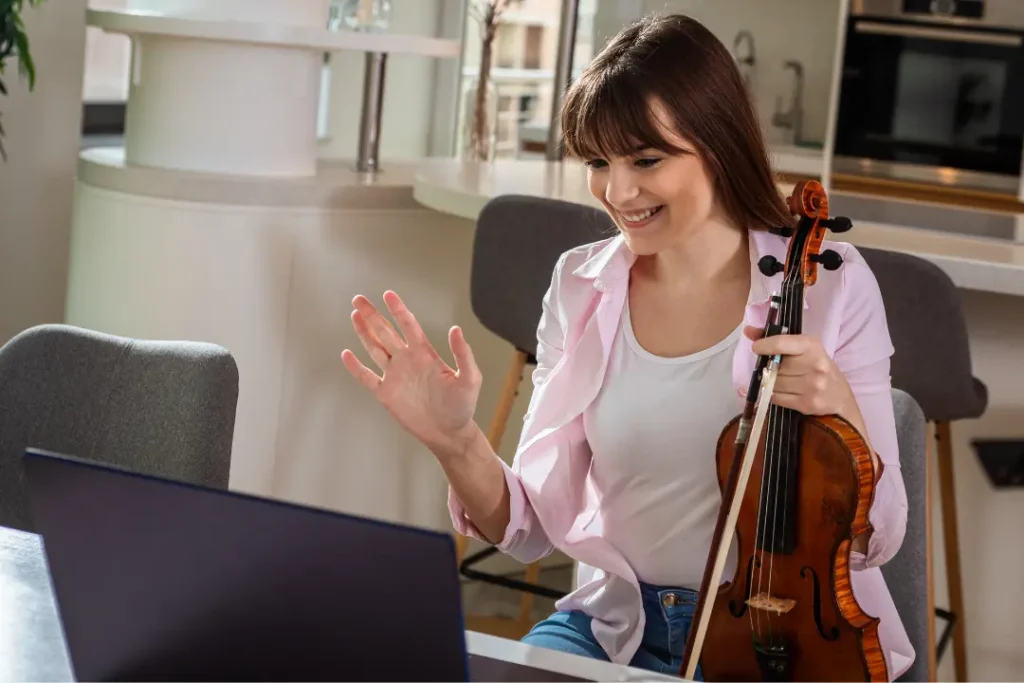 Adult practicing violin at home using online resources