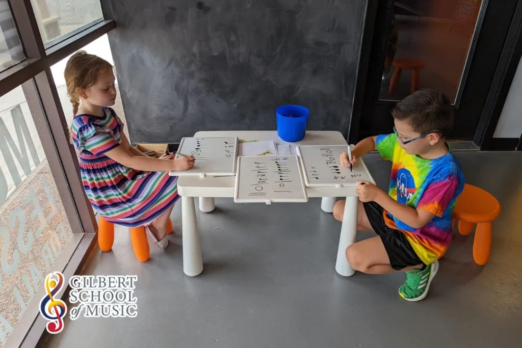 Children participating in a creative summer camp activity at Gilbert School of Music, learning and playing instruments